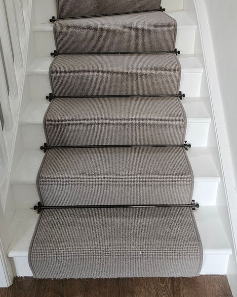 Grey runner with black stair rods on white stairs